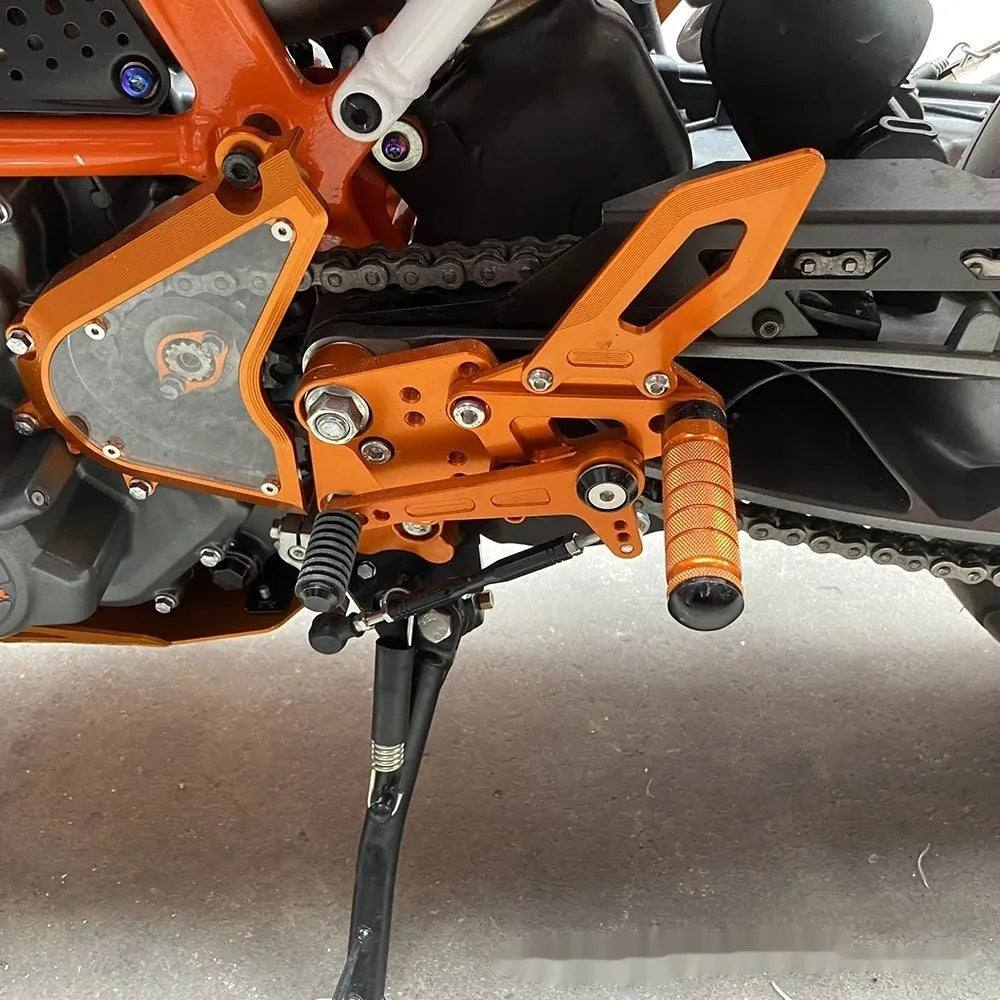 Black and orange KTM DUKE motorcycle footpeg bracket assembly for 125 200 250 390 models