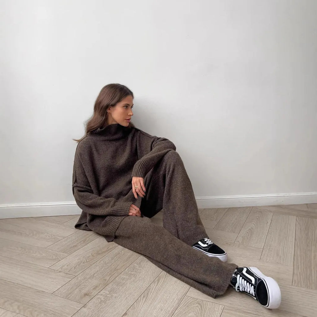 Women's dark grey acrylic knit co-ord set with side-slit sweater and matching trousers laid flat.