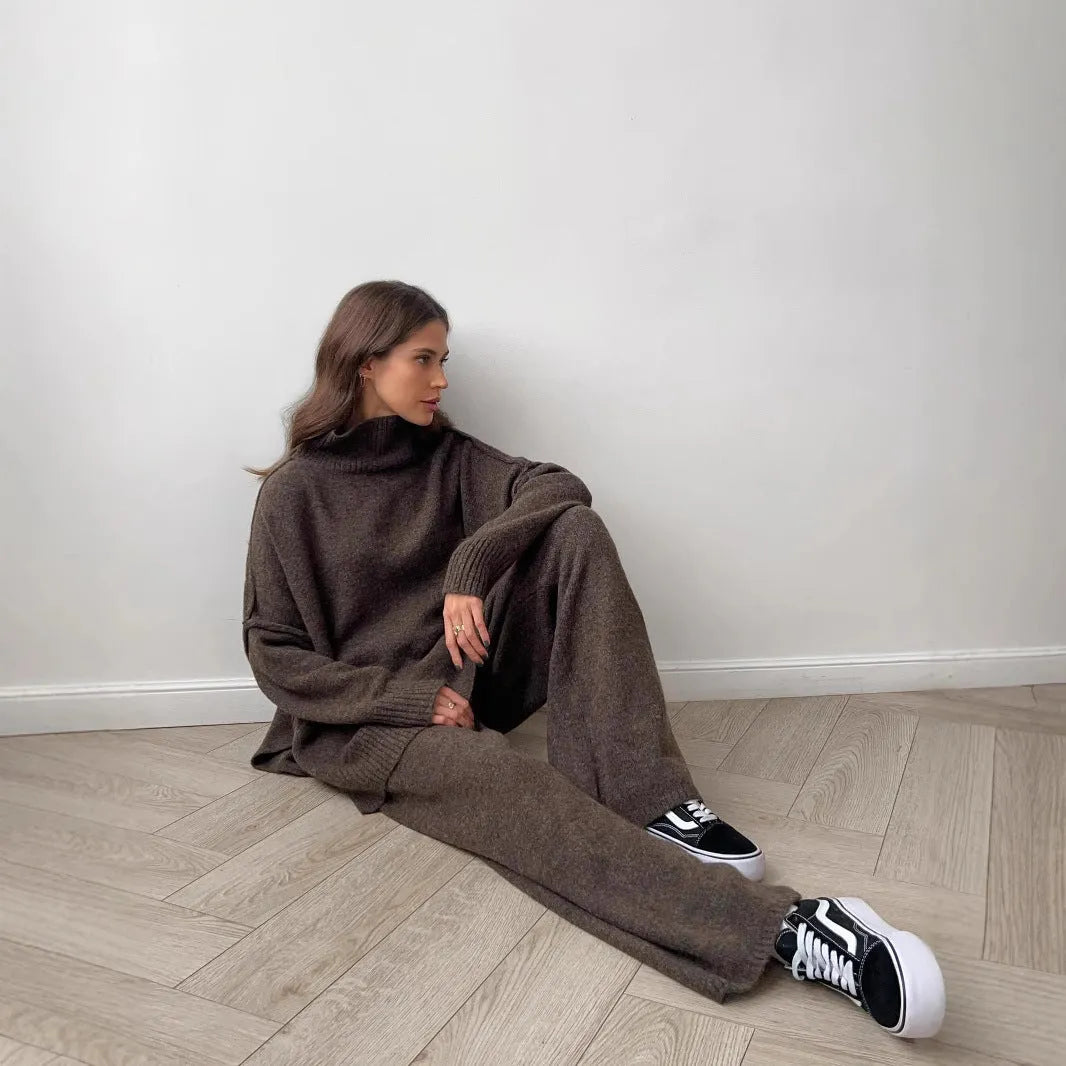 Women's dark grey acrylic knit co-ord set with side-slit sweater and matching trousers laid flat.
