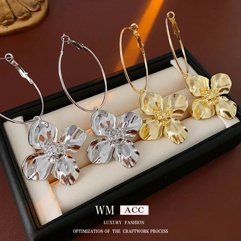 A pair of vintage-style geometric flower earrings with silver needle detailing, shown in gold and silver colour options.