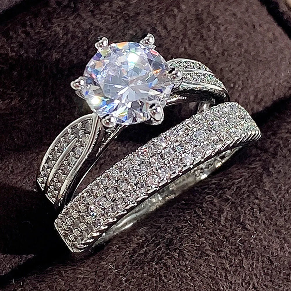 A geometric white gold-coloured alloy wedding ring bracelet on a finger, showing its continuous band design with a round detail.