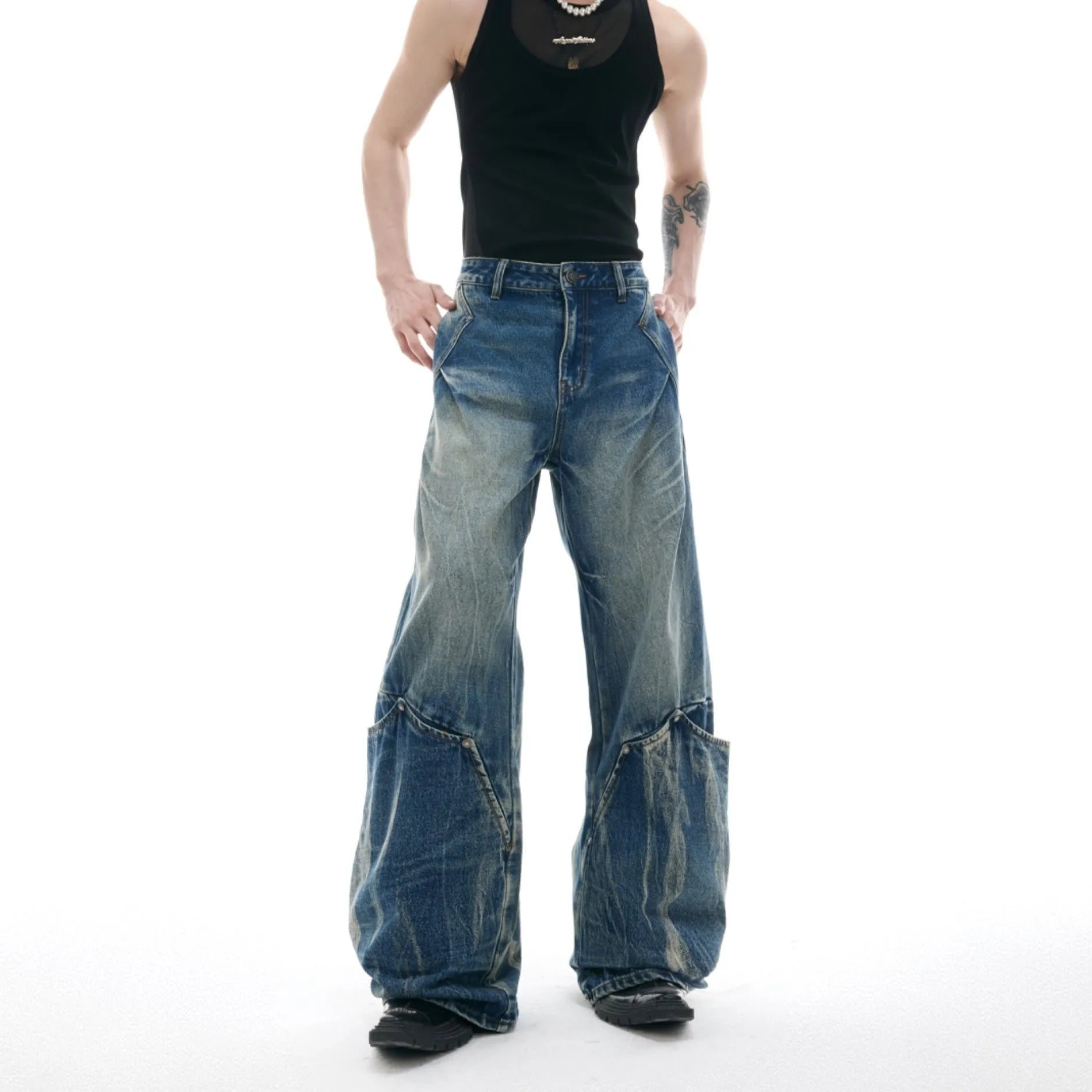 Man wearing verdant blue loose-fit jeans with a burst pattern wash and curved knife cut, front and side view.