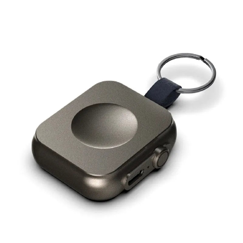 Mini magnetic mobile wireless power supply in black on a table with a smartphone on top