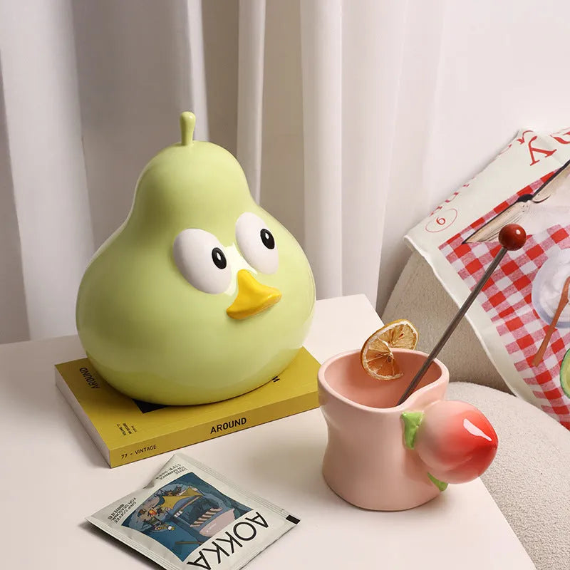 Green ceramic pear-shaped tissue box holder on wooden desk