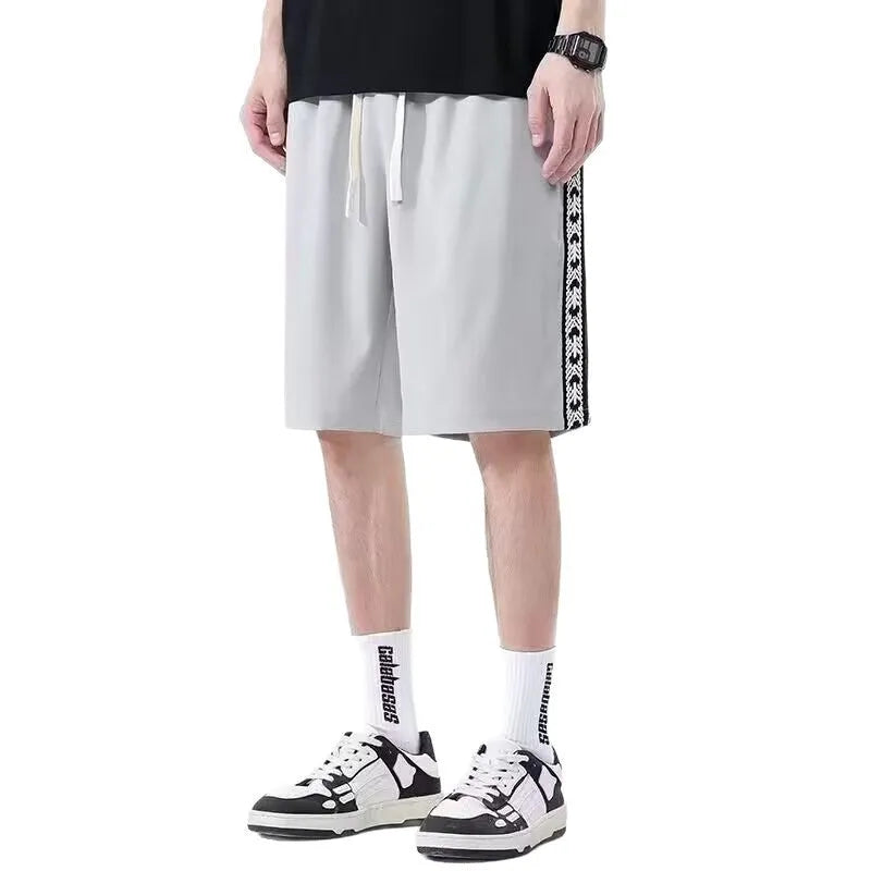Man wearing black loose-fit baggy track pants, showcasing the casual sports style and roomy cut.