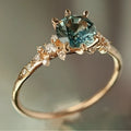 Gold coloured geometric ring with a claw setting holding a zircon stone, showing a chamfered square band.