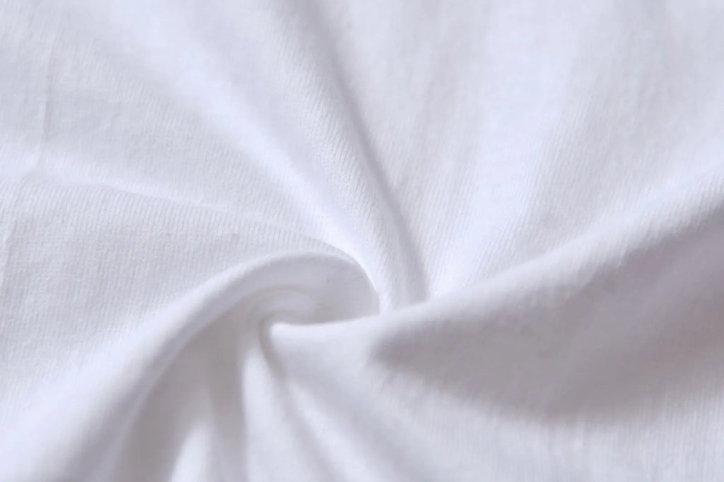 White cotton pullover overalls with short sleeves and a round neck, shown on a hanger.