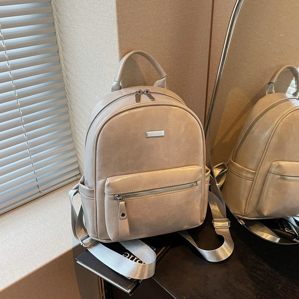 Simple fashion trendy ladies travel backpack in waterproof PU with sandwich pocket, available in multiple colours