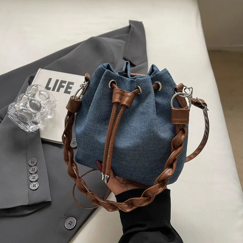 Blue synthetic leather cross-body bucket bag with adjustable strap and outer pocket