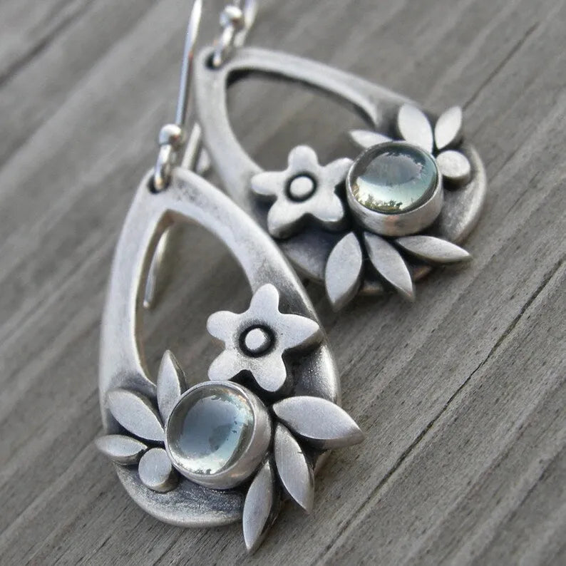 Silver ethnic style minimalist drop flower leaf alloy earrings with teardrop shape on neutral background
