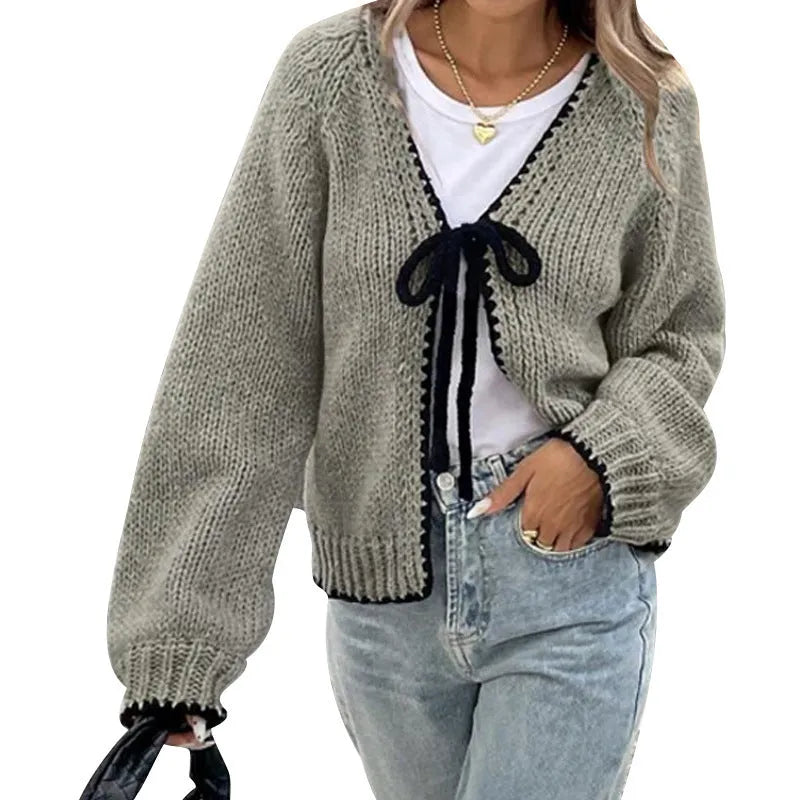 A solid colour loose-fit cardigan with long sleeves and small crochet flower details on the front.