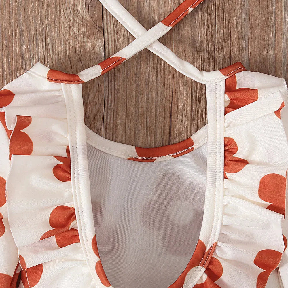 Girl's floral print open back swimsuit in orange, showing crew neck and briefs style.