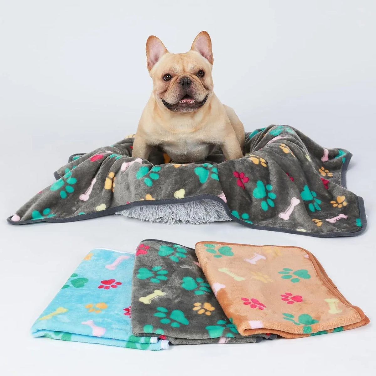 Three flannel coral fleece pet blankets in dark grey, camel, and sky blue stacked together showing size S