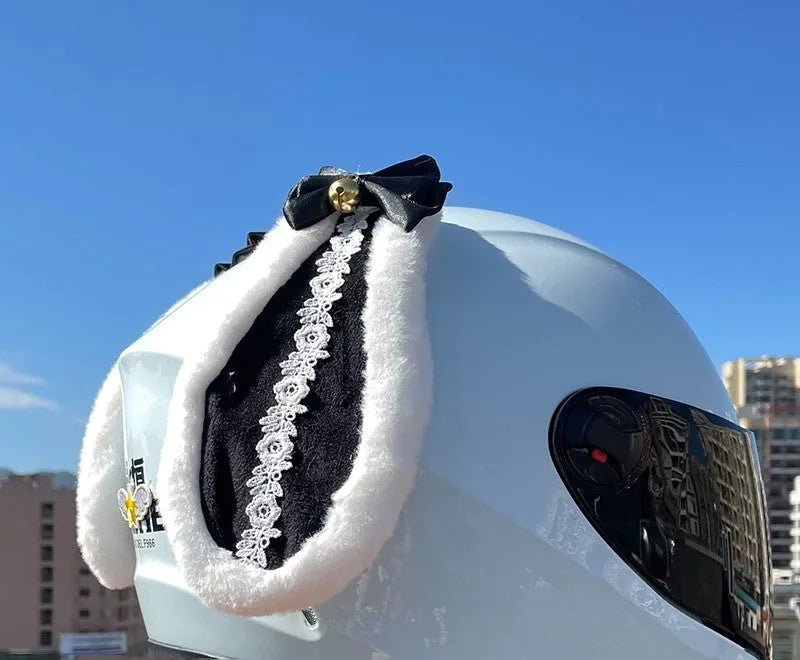 Carbon fibre rabbit ear decoration attached to a black motorcycle helmet, showing clip-on mechanism.