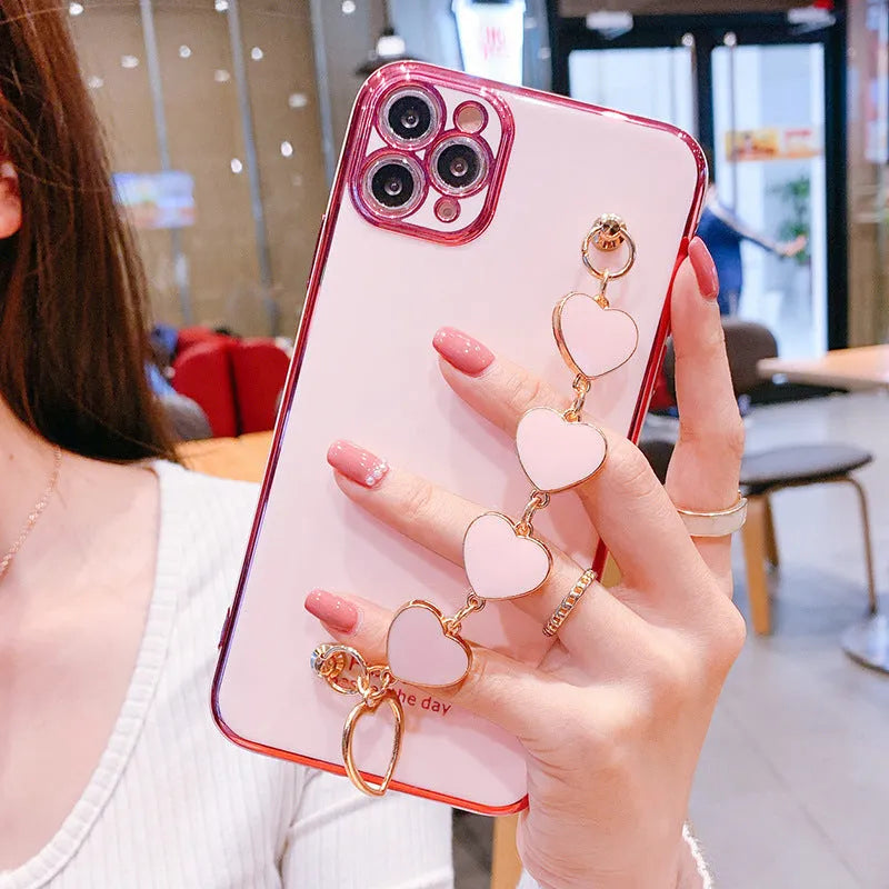 Solid colour silicone phone case with an integrated white protective bracelet on a table.