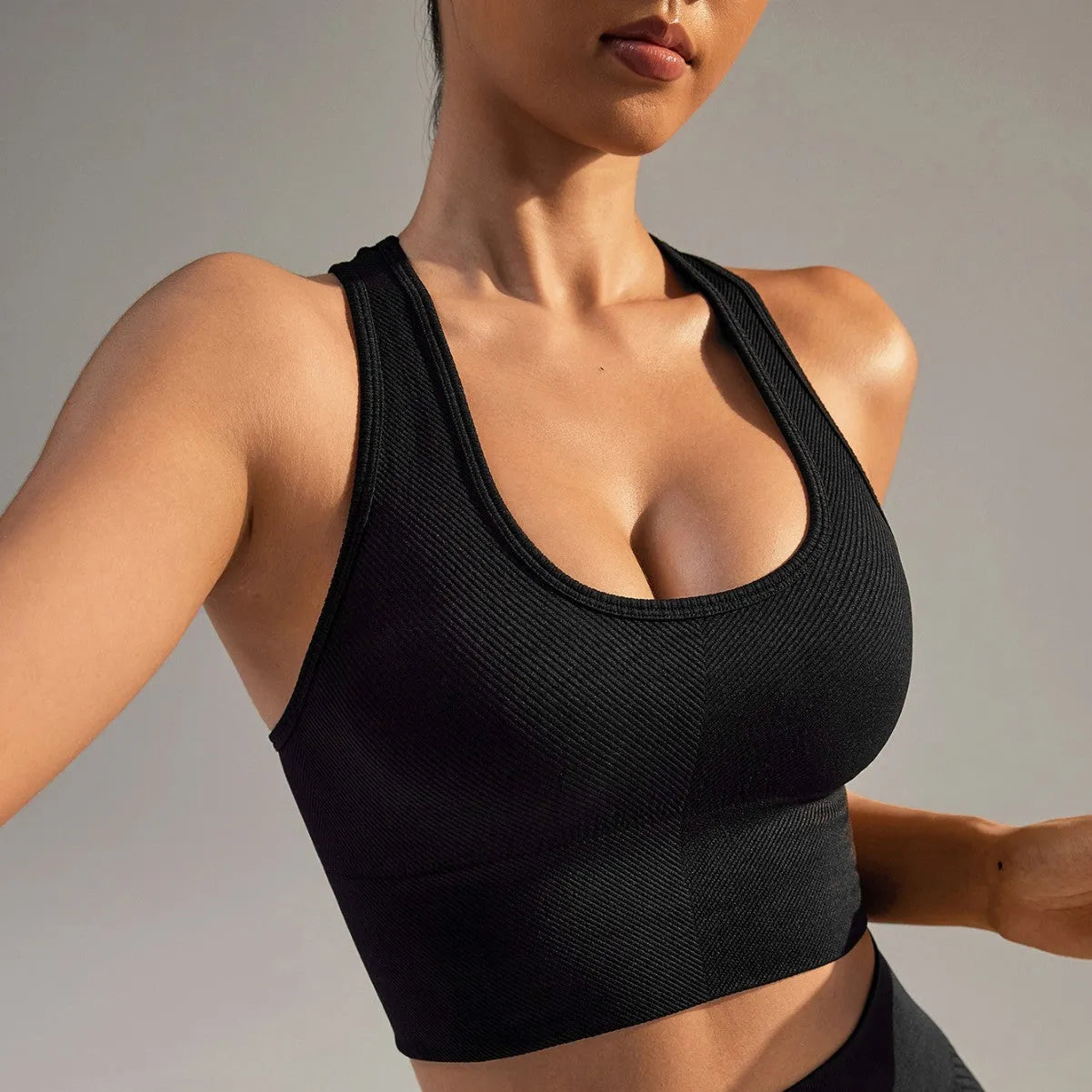 Black women's cross-back sports bra with moulded cups on a hanger