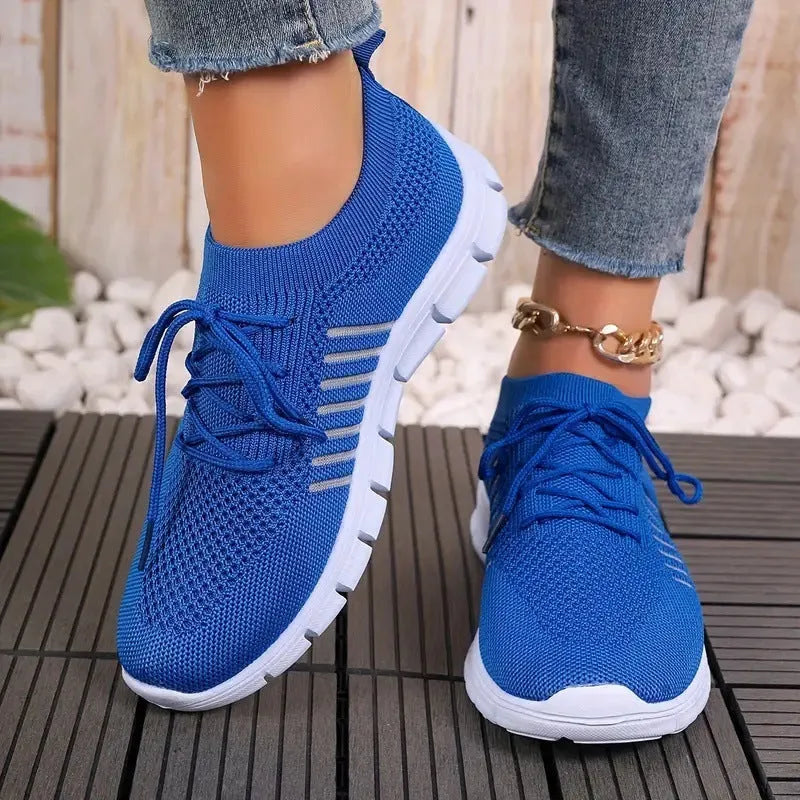 Women's casual flying knit mesh sports flat shoes in a light colour with front lace-up design.