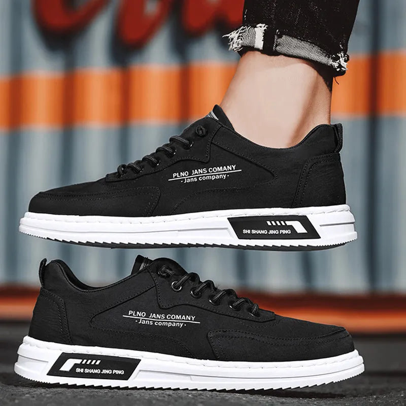 Men's green canvas lace-up sneakers with round toe, flat heel, and letter print side detail on a white background