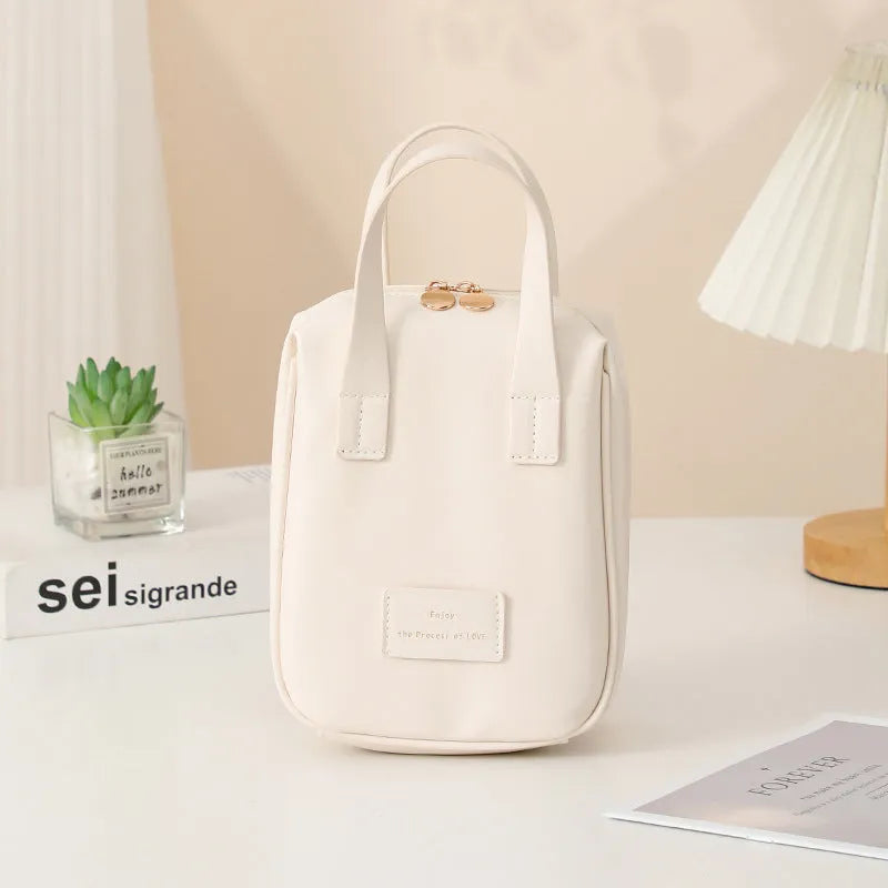 Shell-shaped handle-top cosmetic bag in cream white, PU material, 20x16x8 cm, for travel make-up storage