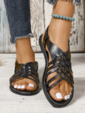 Flat buckle open toe Roman style beach slippers in black shown on a light background.