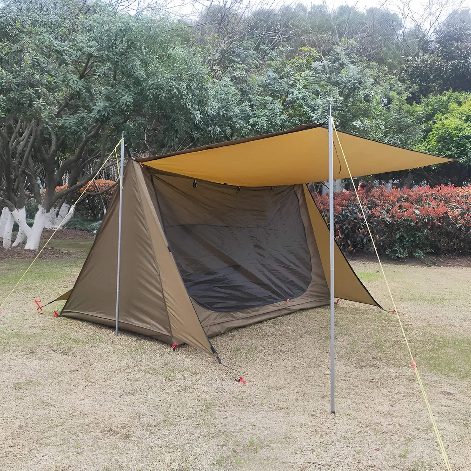 Brown single-layer shelter tent for two to three people with aluminium alloy rods set up on grass