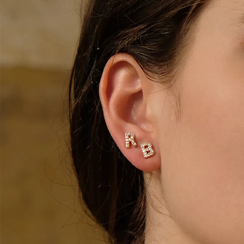 Gold plated brass earring in the shape of the letter A, set with a sparkling zircon stone.