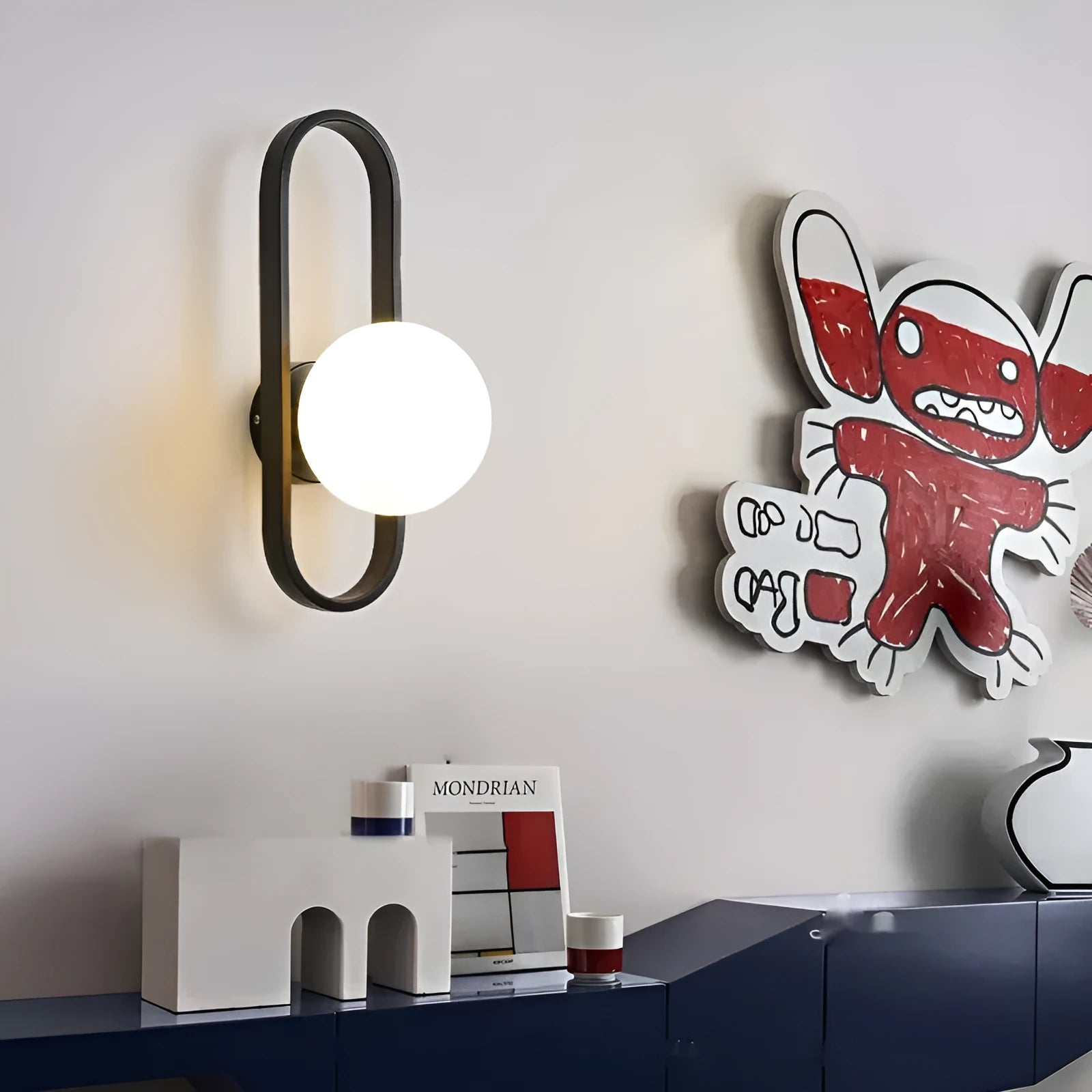 Modern minimalist wall lamp with clear glass shade and black iron mount, showing three light colour settings.