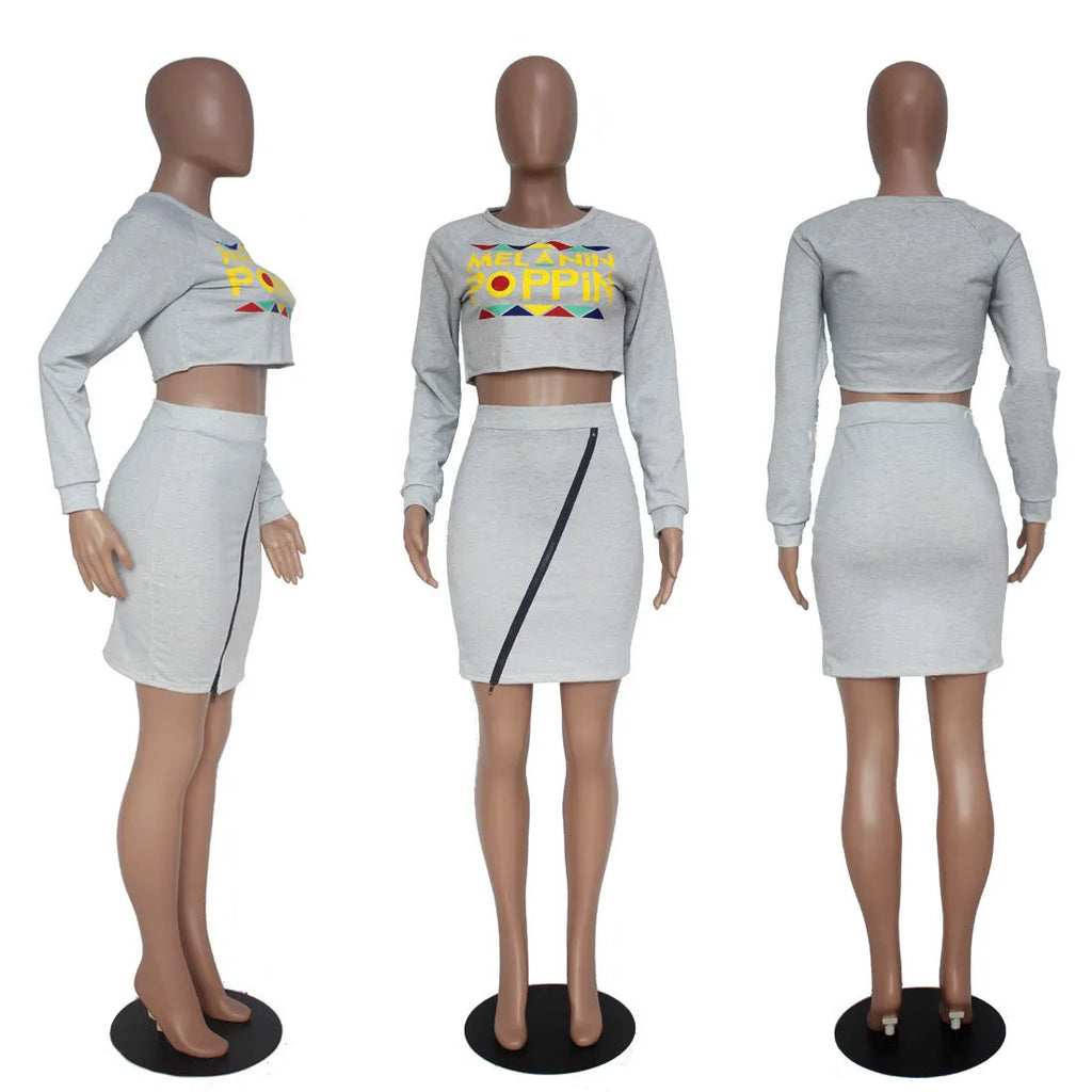 Women's gray letter print skirt suit with long sleeve zipper top and short skirt on mannequin
