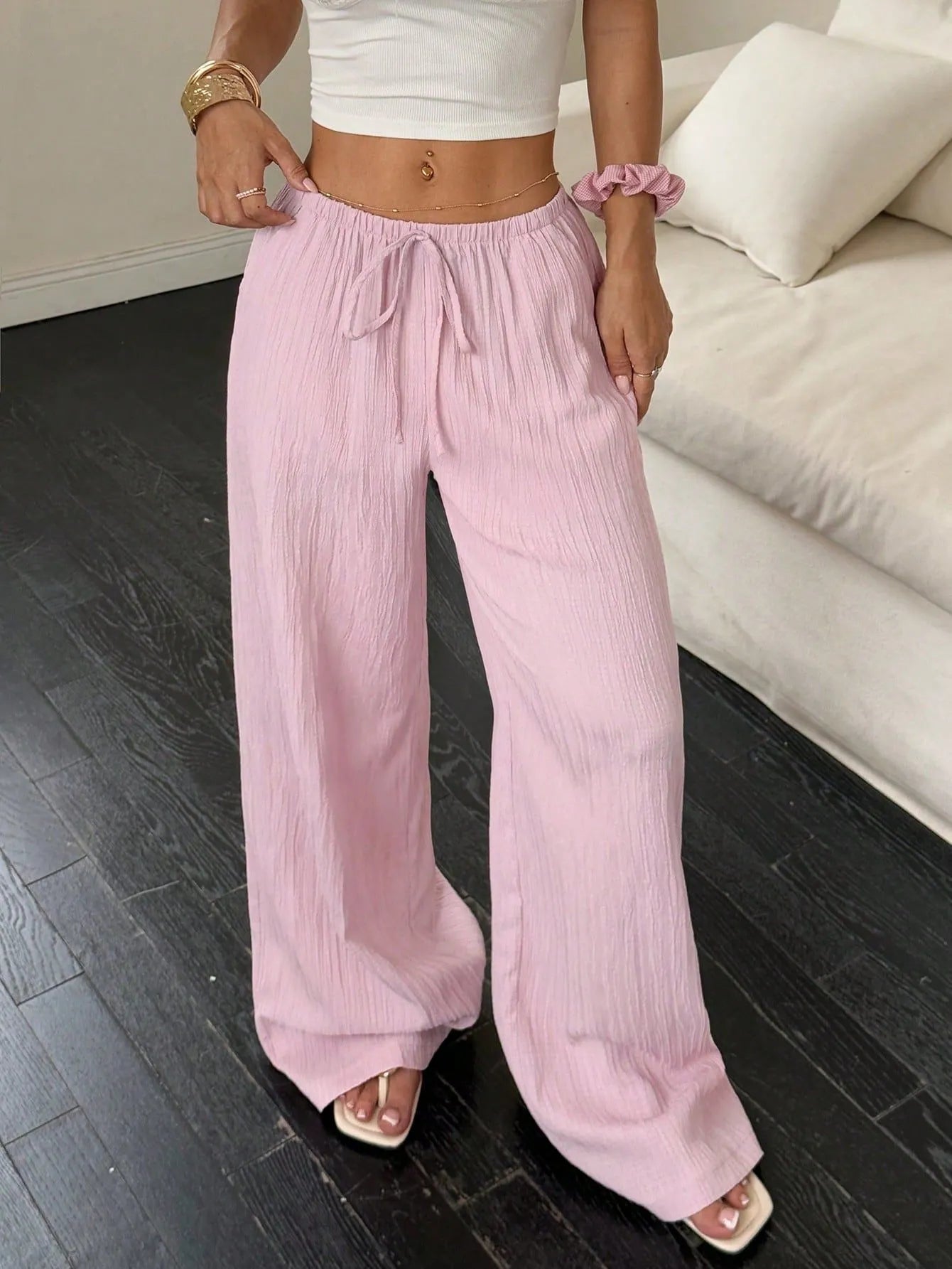 Women's black wide-leg trousers with a front lace-up waist detail on a mid-rise waistband.
