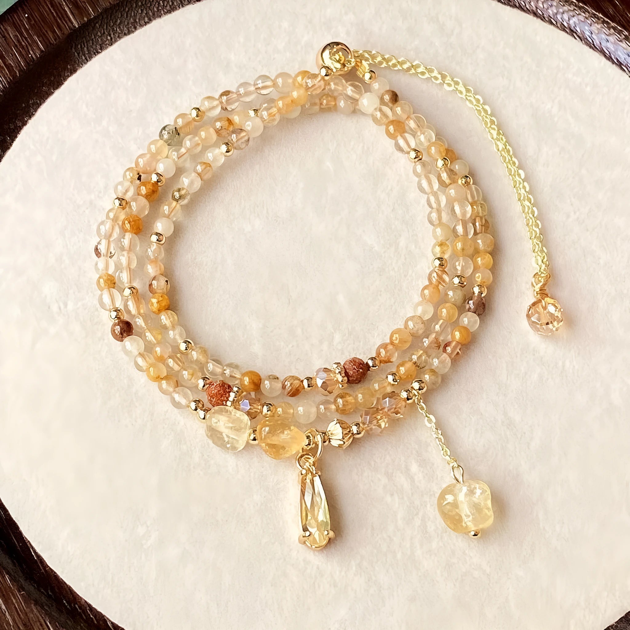 Gold electroplated women's bracelet with three interlinked circles made from natural caramel-coloured citrine and a Saturn decoration.