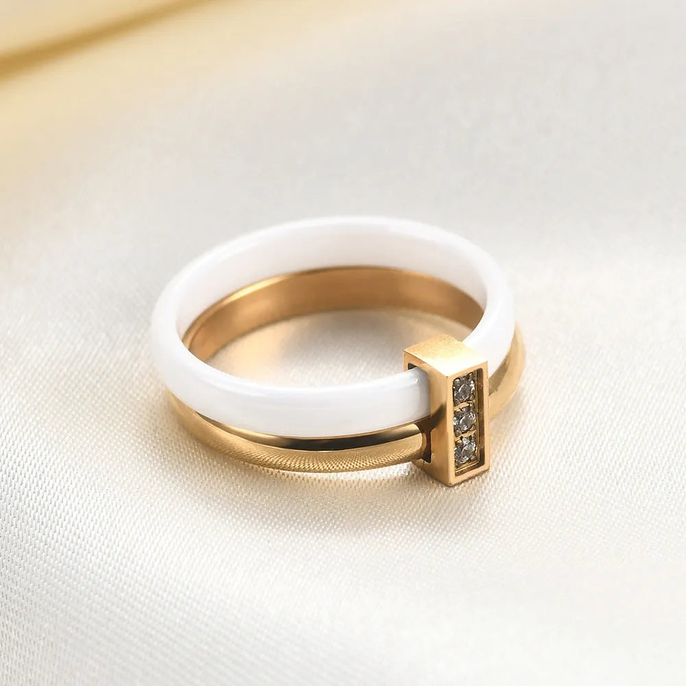 Geometric glossy ceramic women's ring with zirconium inlay, shown in steel black and gold white.