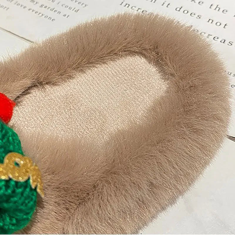 Women's faux plush slippers with a Christmas hat decoration design in black, shown on a foot.