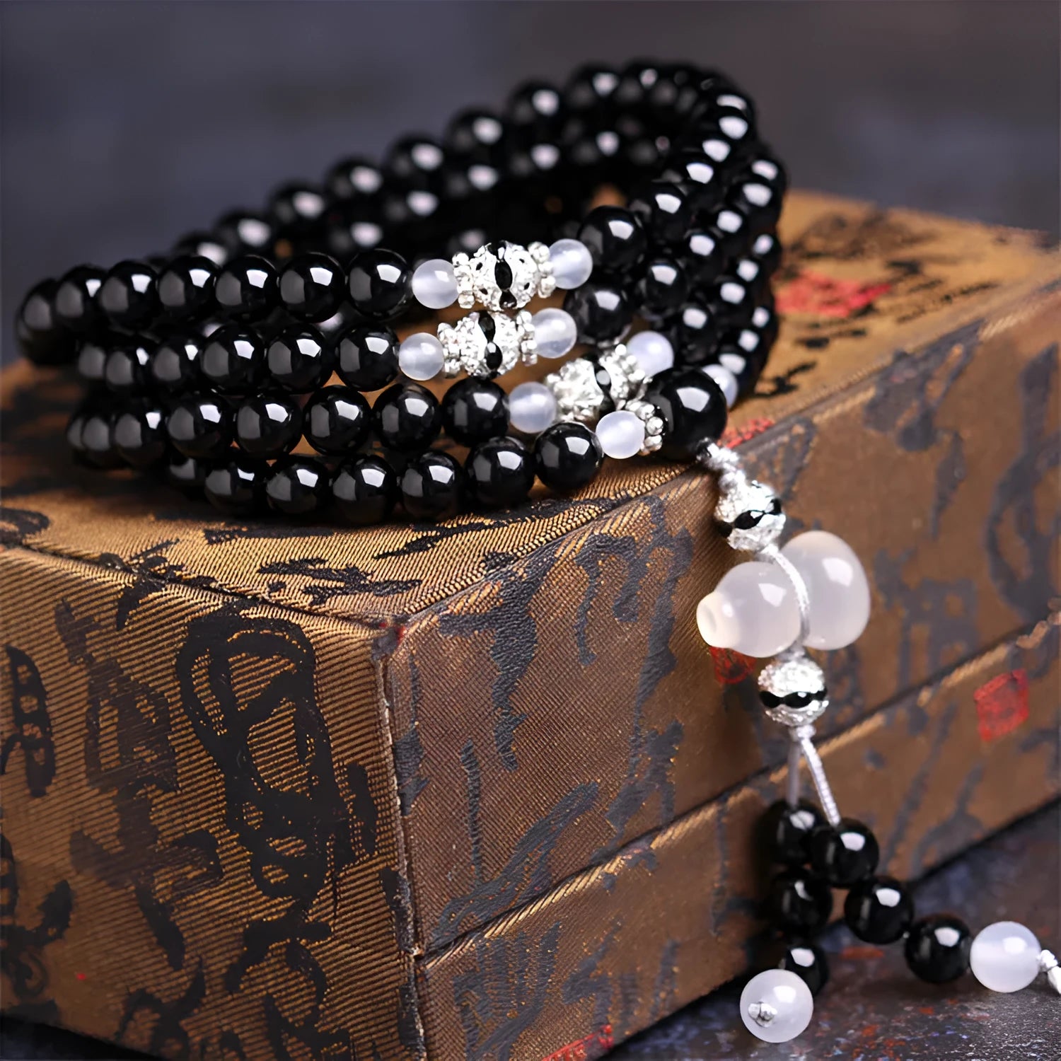 Black and red agate stone bracelet with 108 geometric beads on a wrist