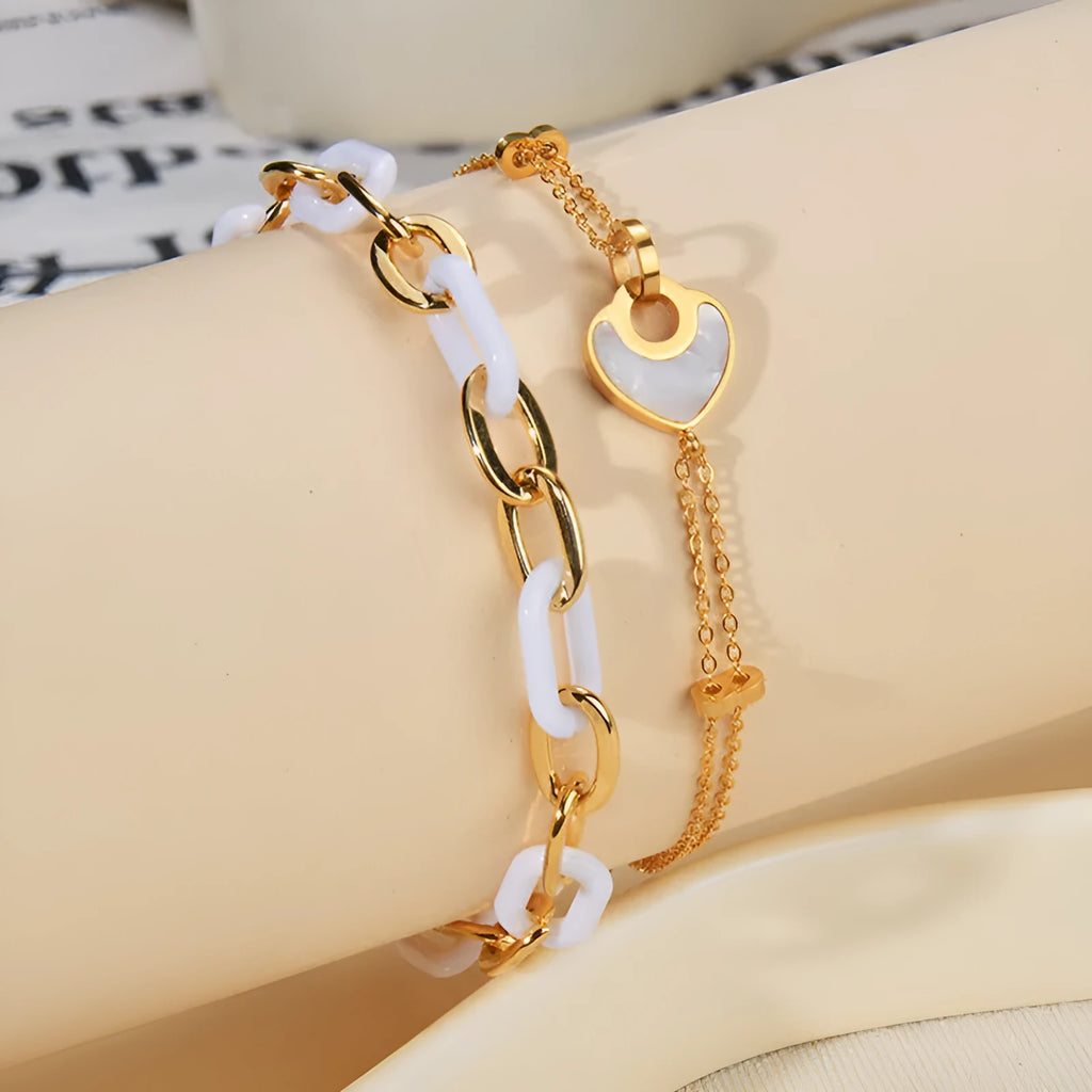 Close-up of a women's stainless steel bracelet with a double-layered heart pendant.