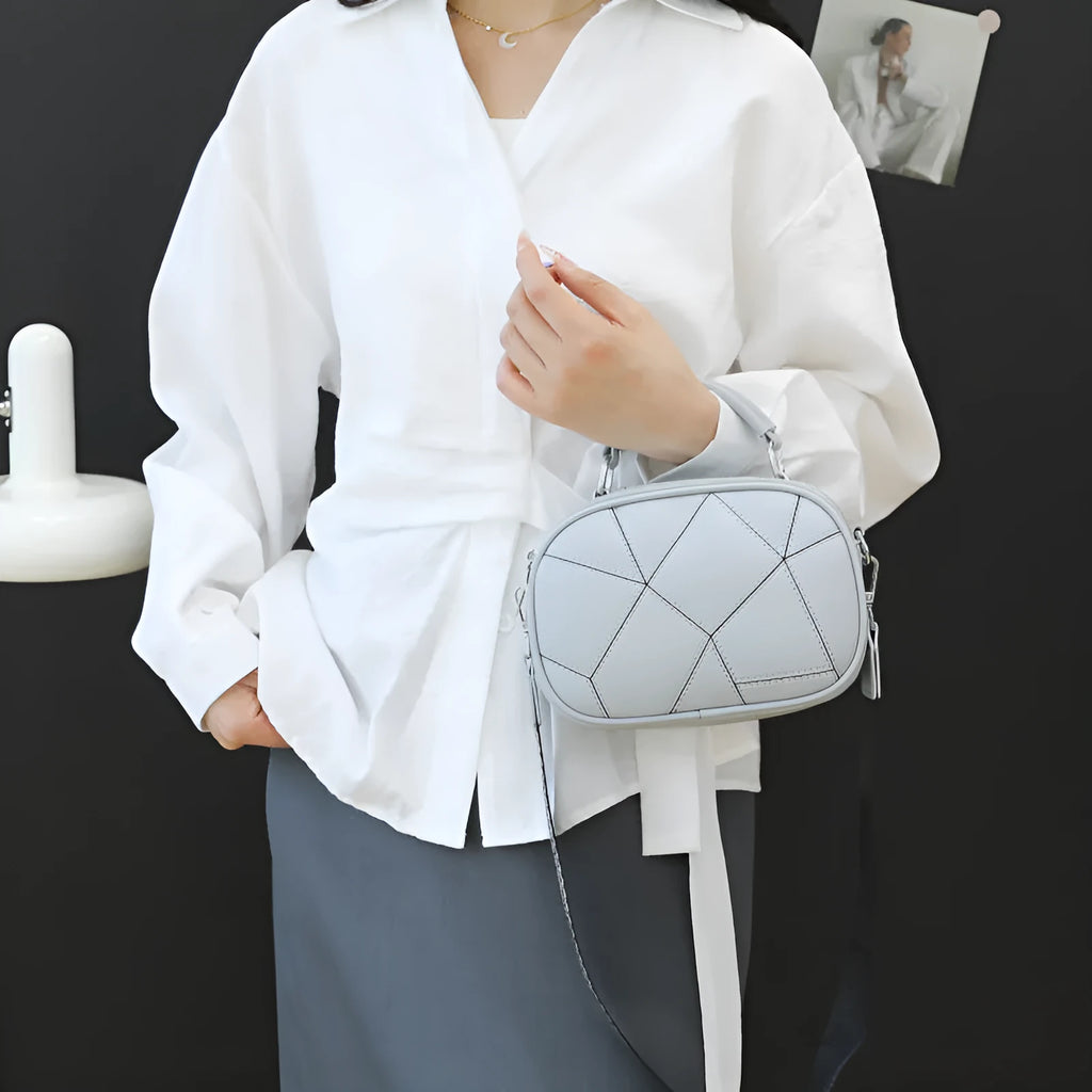 Small round patchwork bag in PU with visible stitching details, shown in beige colour
