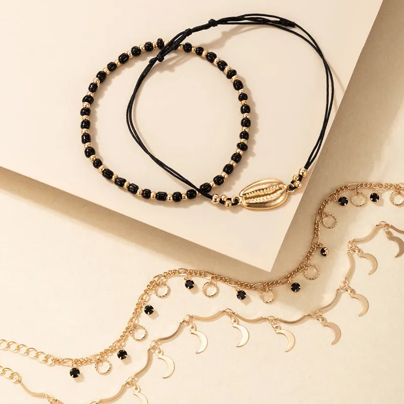 Women's gold tone alloy anklet set with hollow circles, shell beads, and black rice beads, four pieces