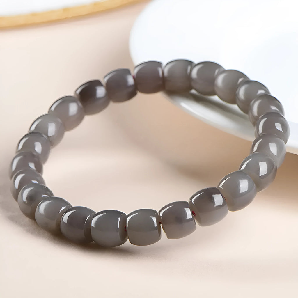 Straight cut Hetian jade bracelet in natural smokey violet colour on a wrist, showing polished 8x9mm beads.