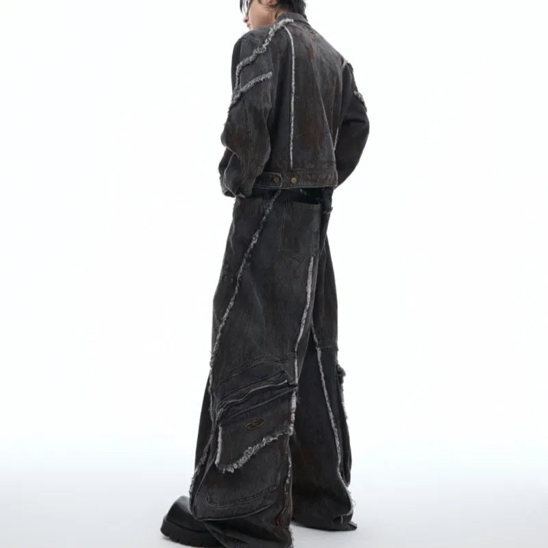 Black raw edge splash-dye distressed denim coat with padded shoulders and matching pants laid flat.