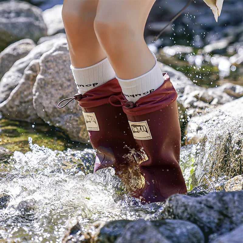 PVC waterproof high tube rain boots in beige, black, green, and red colours on a white background.