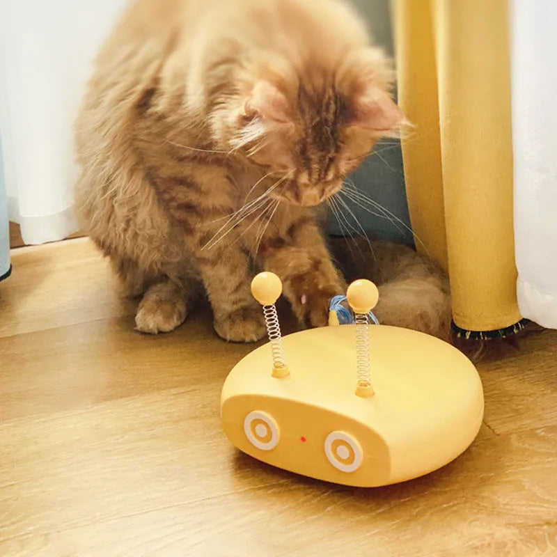 Blue rechargeable robot cat toy with laser pointer and feather attachments on grey floor