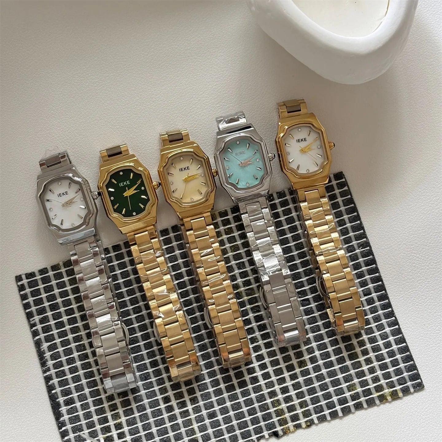 Women's small square watch with gold strap and green dial, 10mm thin, on wrist