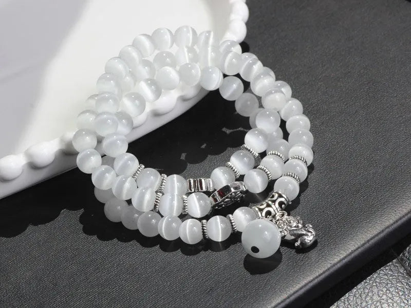 Women's opal bracelet with lucky cat charm, shown in a triple-wrap style with colourful geometric beads.