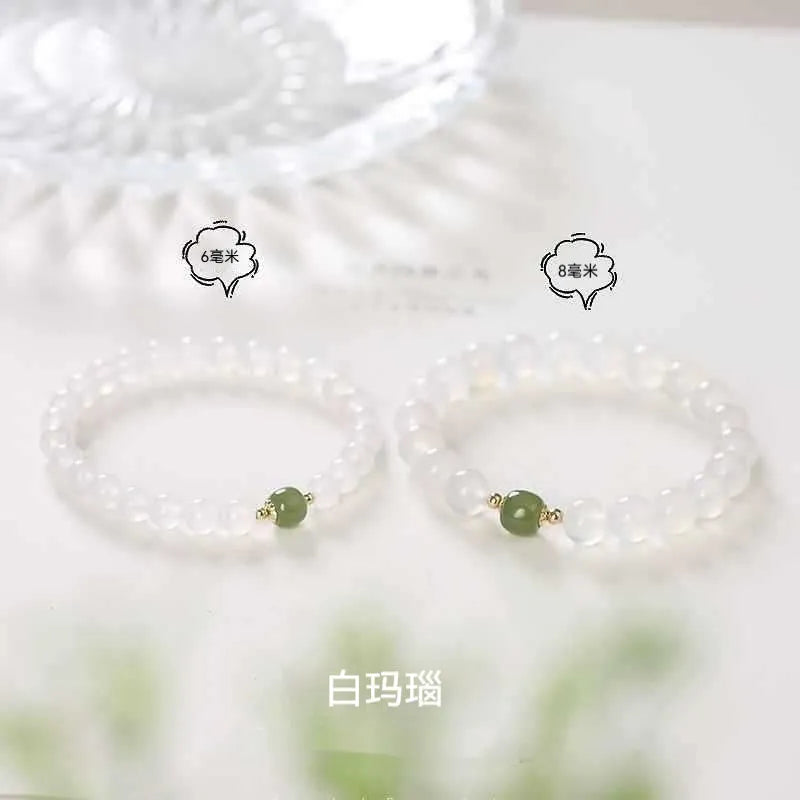 Handmade white agate and crystal bracelet with cinnabar inlay, showing text design on beads
