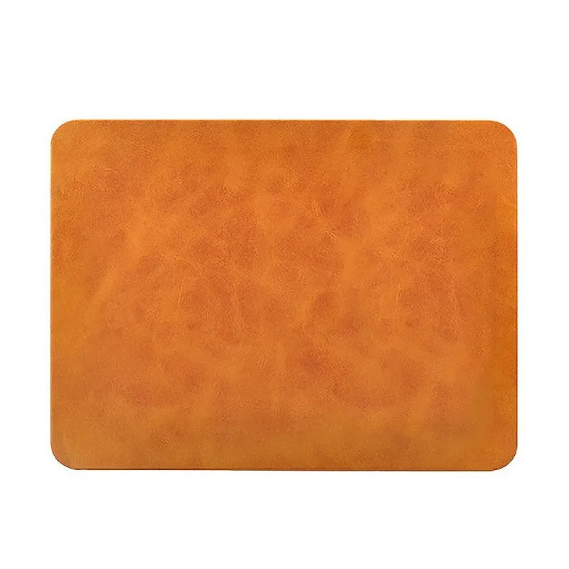 Brown leather-textured wireless charging mouse pad with a Micro USB cable on a wooden desk.