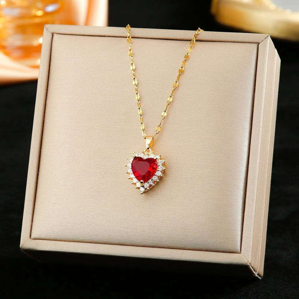 Titanium steel necklace, earrings, and ring set with heart, flower, and suit symbols in gold-red finish with gem inlay.