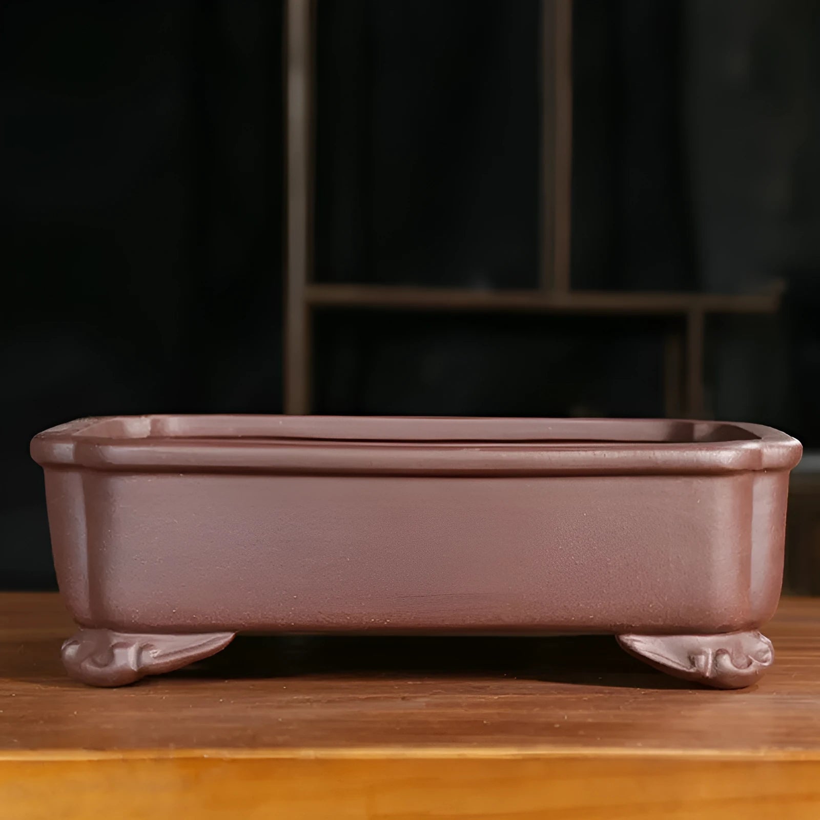 Rectangular antique purple sand bonsai pot with cut corners on a floor.