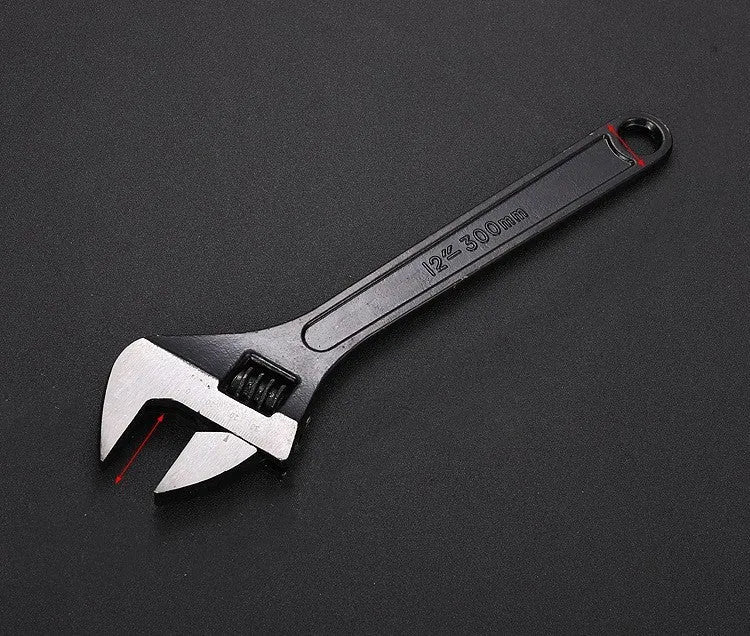 High carbon steel adjustable open-end wrench with black finish on a workbench.