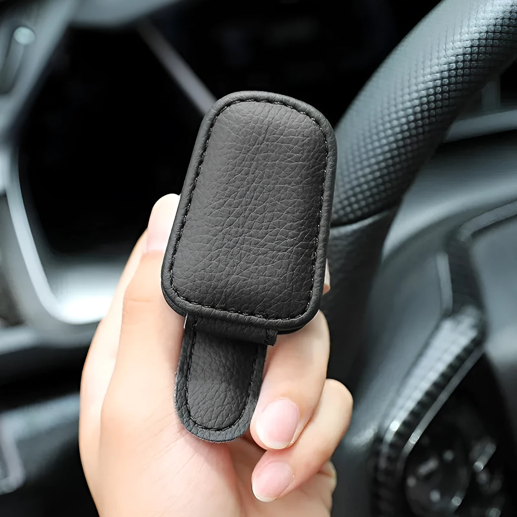 PU leather car sunglasses clip holder mounted on a grey sun visor.