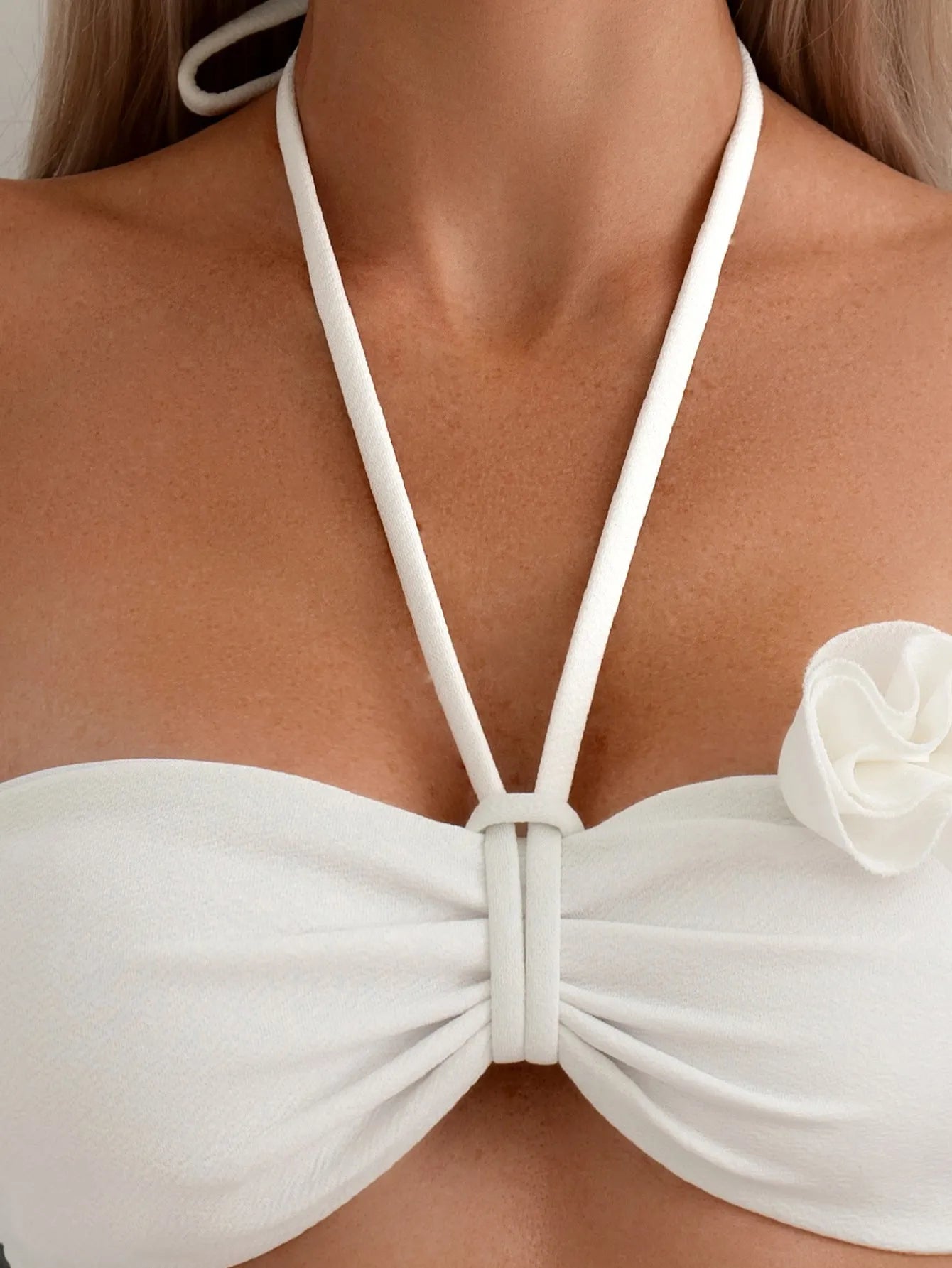 White halter neck bikini set with lace-up back and three-dimensional floral pattern on briefs.