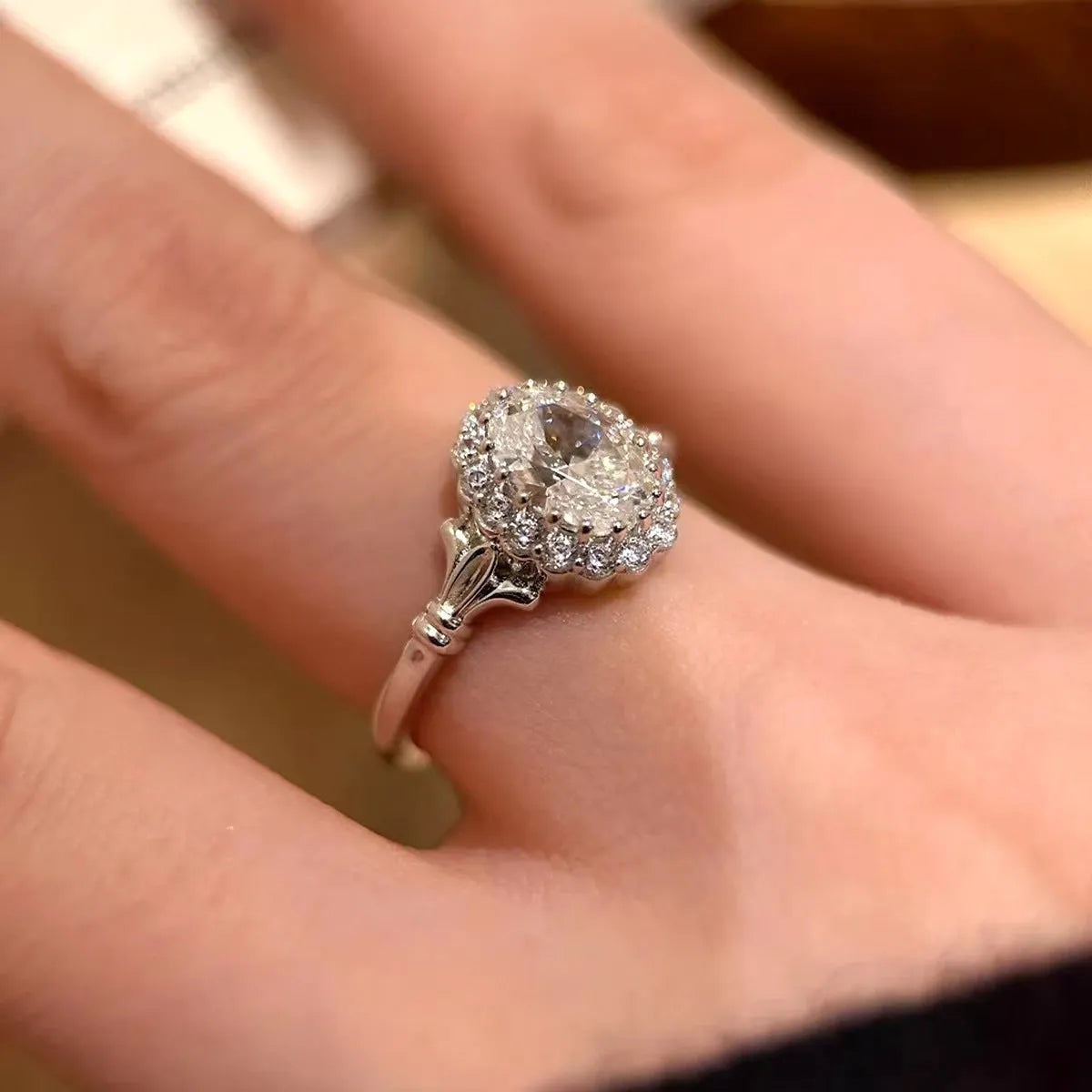 Silver-colour geometric ellipse women's ring with central diamond on an adjustable band.